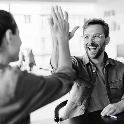 Colleagues exchanging a high-five as a symbol of their teamwork and combined efforts